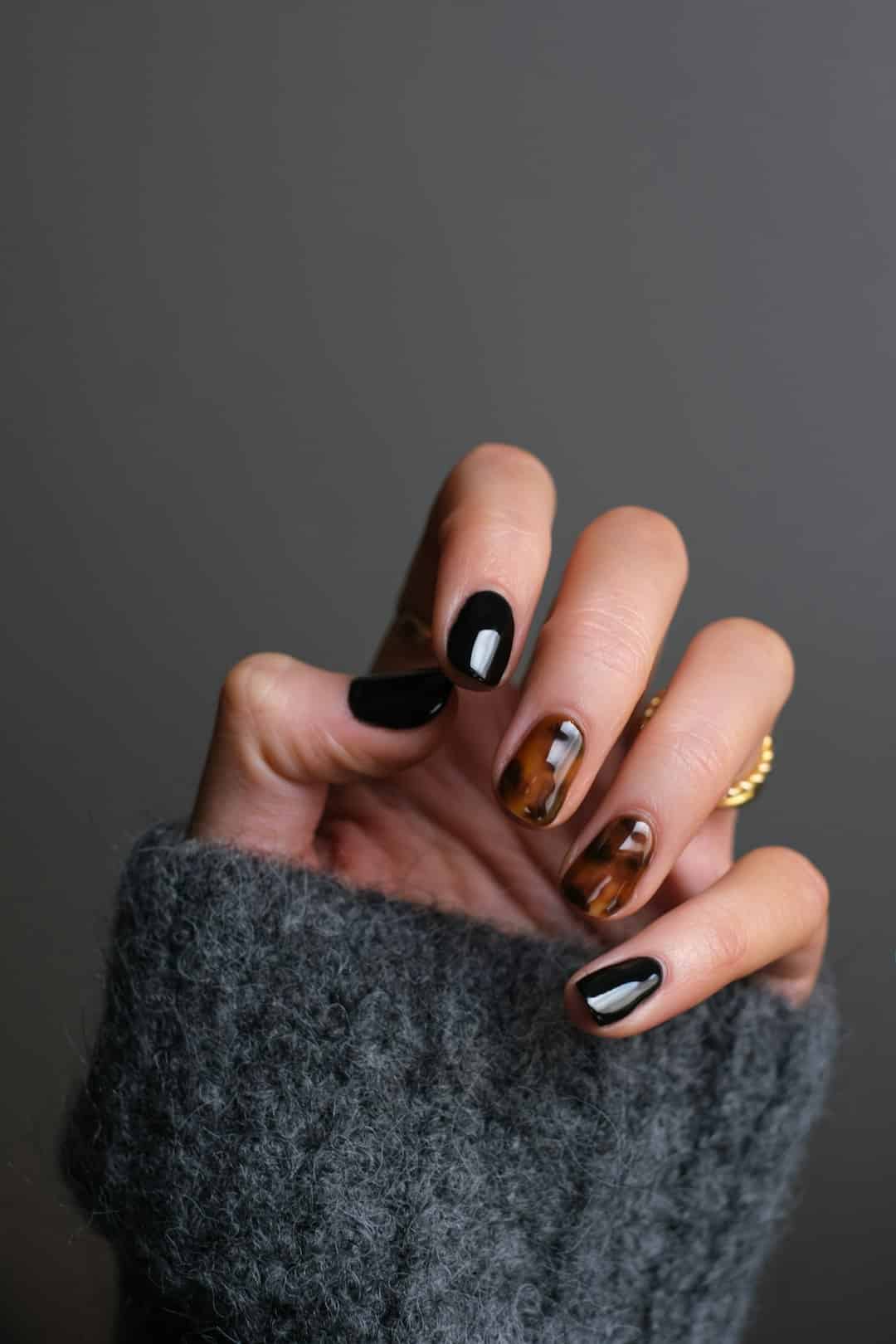 Understanding the Meaning Behind gingerbread nails infection person wearing gold ring holding black textile